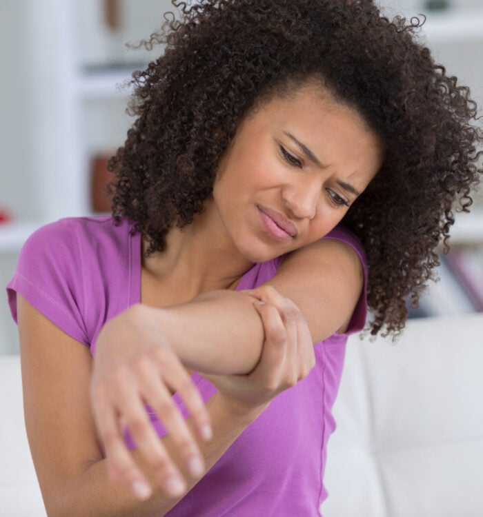Woman holding painful elbow