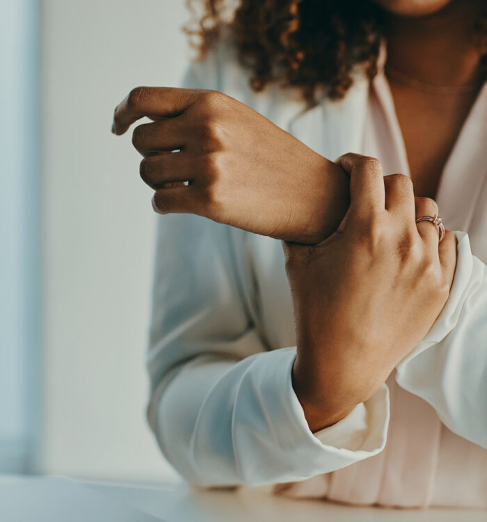 Shot of an unrecognisable businesswoman experiencing wrist pain while working in a modern office
