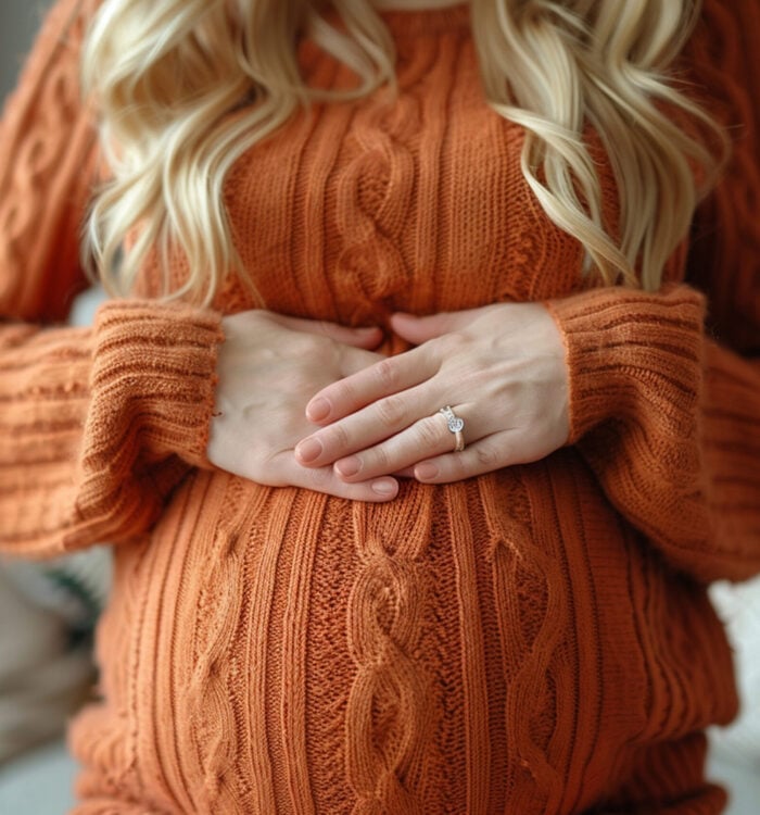 Pregnant woman holding her lower back, red showing back pain