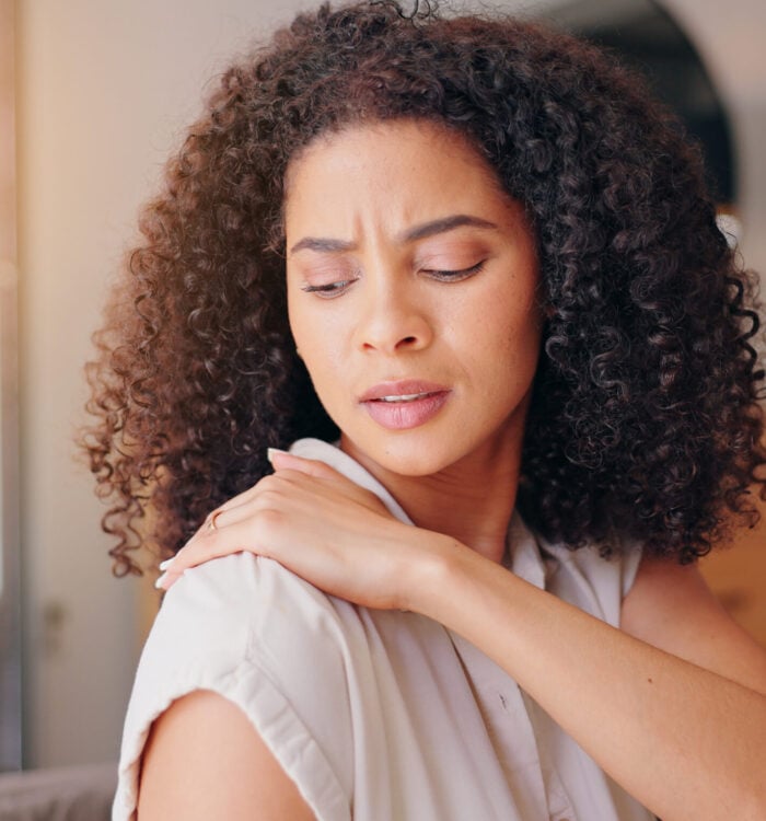 Woman, shoulder pain and injury in home with stress, thinking and hand for massage for relief. Girl, person and burnout with muscle, strain or arthritis with ideas, rub or sad in morning at apartment.